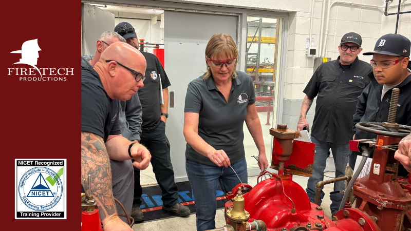 A Fire Tech instructor points to a valve while students look on.